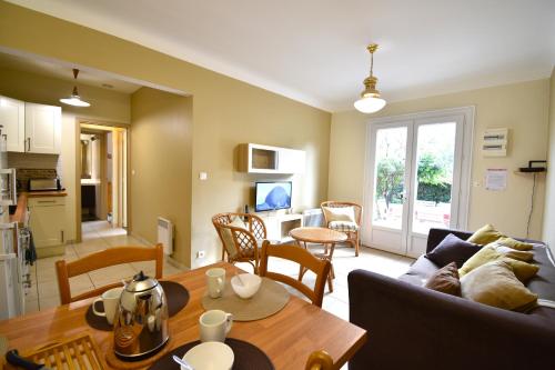 un salon avec un canapé et une table dans l'établissement Anlga - Hossegor villa mitoyenne de plain pied rénovée avec jardinet clos et terrasse, à Soorts-Hossegor