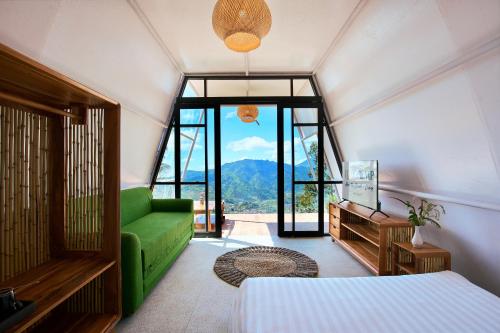 a bedroom with a bed and a green couch at Luxcamp Dieng by Horison in Garung