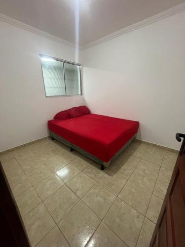 a bedroom with a red bed in a room at Casa com Piscina individual in Paulista