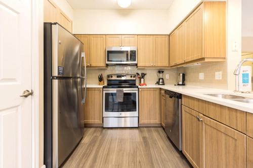a kitchen with wooden cabinets and stainless steel appliances at Spacious Apt with Private Balcony in Waltham