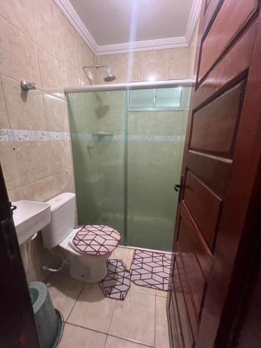 a bathroom with a toilet and a glass shower at Casa com Piscina individual in Paulista