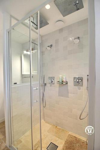 a bathroom with a shower with a glass door at Villa Namasté SPA Hammam port & Mer in La Trinité-sur-Mer