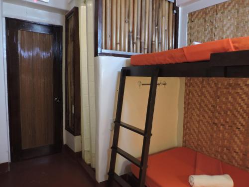 a dorm room with a bunk bed and a door at Orange Mangrove Pension House by SMS Hospitality in Puerto Princesa City
