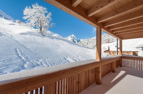 a snow covered porch with a view of a mountain at Alpin Chalet Schröcken in Schröcken