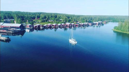 a sailboat is docked at a dock in the water at Hotell Mellanfjärden in Jättendal