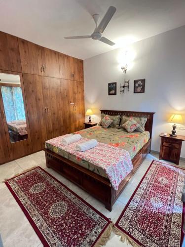a bedroom with a bed and two rugs at The Cider 1bhk Apartment Goa - Sleeps 4 in Palolem