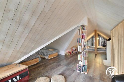 a attic room with two beds and a book shelf at Villa Namasté SPA Hammam port & Mer in La Trinité-sur-Mer