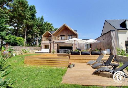 a backyard with a wooden deck and a house at Villa Namasté SPA Hammam port & Mer in La Trinité-sur-Mer