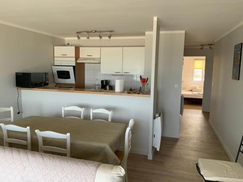 une cuisine et un salon avec une table et des chaises dans l'établissement Superbe appartement vue mer 4 personnes, à Merlimont