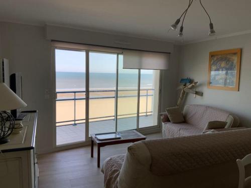 - un salon avec un canapé et une vue sur la plage dans l'établissement Superbe appartement vue mer 4 personnes, à Merlimont