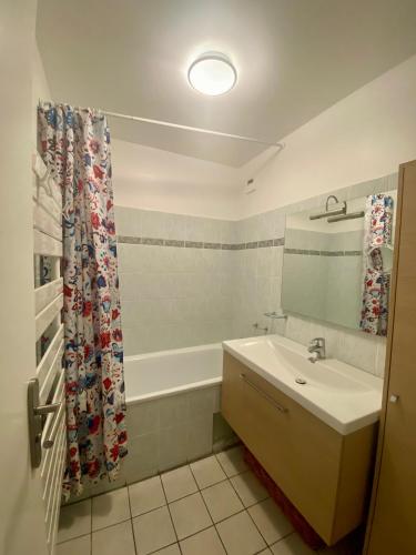 une salle de bain avec un lavabo et un rideau de douche dans l'établissement Les Arcs 1600 Vaste appartement 4 couchages 2 chambres, à Arc 1600