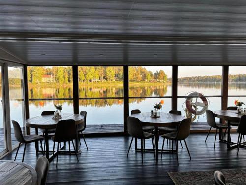 a restaurant with tables and chairs and a view of a lake at Hotell Mellanfjärden in Jättendal