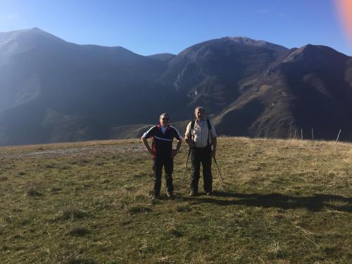 two men standing in a field with mountains in the background at Al Villino del Sole in Fano