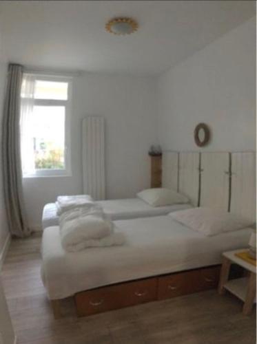 a bedroom with two beds and a window at Villa Chantereyne entrée de plage, 8 couchages in Ouistreham