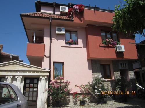 a pink building with flower boxes on it at Guesthouse Olimp in Sozopol