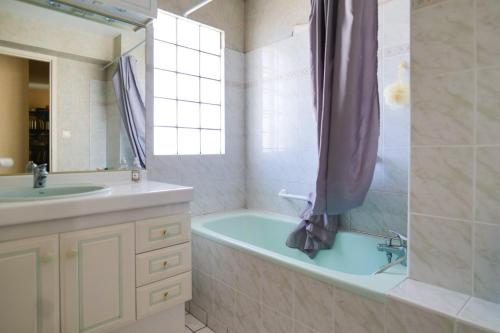 a bathroom with a tub and a sink and a shower at Appartement proche plage, quartier des Présidents, Les Sables - 4 personnes in Les Sables-dʼOlonne