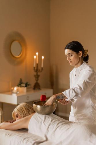 a woman is standing next to a woman laying on a bed at Villa Antica Colonia SPA & Wellness in Pettenasco