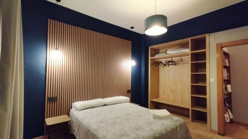 a bedroom with a bed and a blue wall at Segundo Antolín Yellow Door in Ponferrada