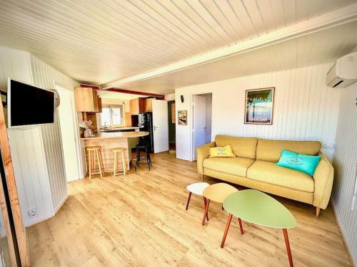 un salon avec un canapé et une table dans l'établissement Chalet 4 à 6 pers Terrasse vue mer, à Gruissan