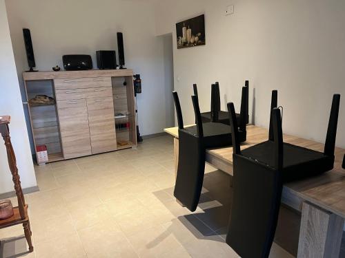 - un salon avec des chaises noires et une commode dans l'établissement Chambre triple, à Viviers