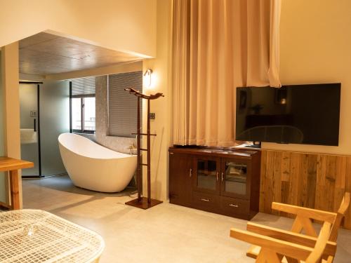 a bathroom with a bath tub and a television at Patio Spring Holiday Inn -- Free round trip pick-up service --Panoramic view of Tianmen Mount in Zhangjiajie