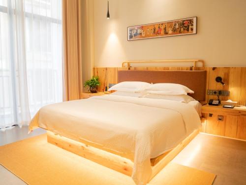 Postel nebo postele na pokoji v ubytování Patio Spring Holiday Inn -- Free round trip pick-up service --Panoramic view of Tianmen Mount