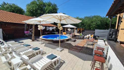 a group of chairs and an umbrella next to a swimming pool at Odmaraliste Kod Miće Apartman 3 in Krušar