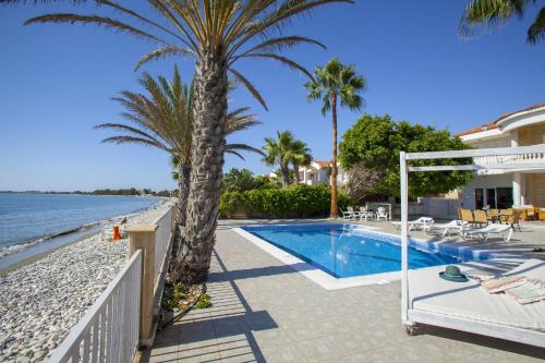 a villa with a swimming pool next to the beach at Meneou Beachfront Villa Sunset in Perivolia