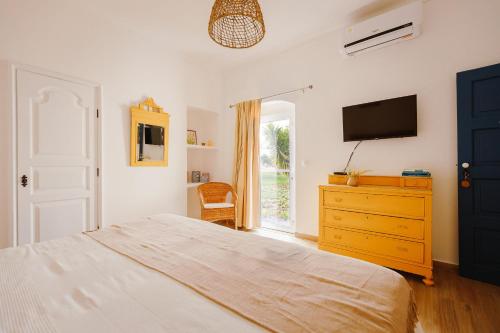 a bedroom with a bed and a dresser with a television at Monte do Ramalho in Avis