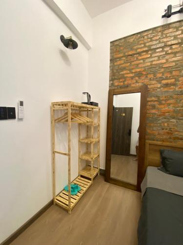 a room with a book shelf next to a brick wall at Lucky coffee & homestay in Thôn Trường Giang