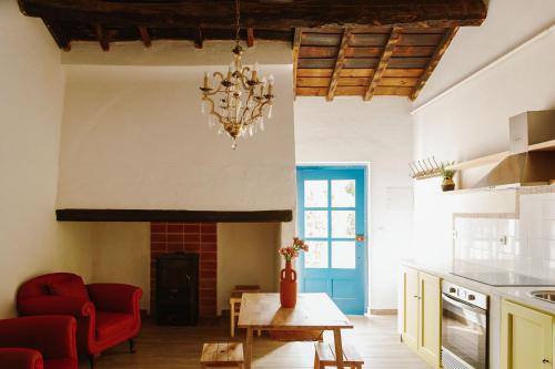 a living room with a fireplace and a chandelier at Monte do Ramalho in Avis