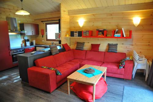a living room with a red couch and a kitchen at Anemoon in Oignies