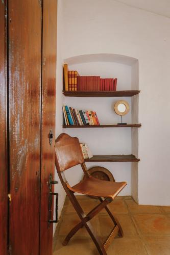 a wooden rocking chair in a room with a fireplace at Monte do Ramalho in Avis