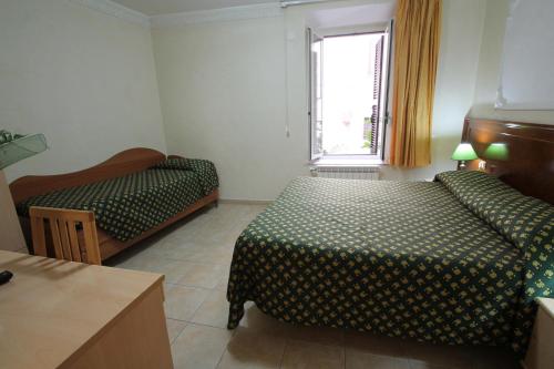 a hotel room with two beds and a window at Rosetta in Rome