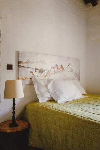 a bedroom with a bed with a painting on the wall at Monte do Ramalho in Avis