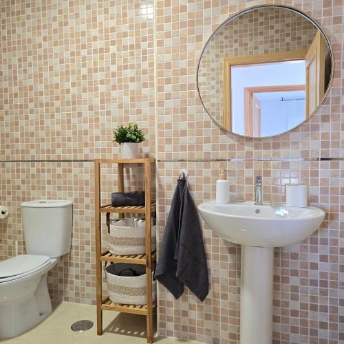 a bathroom with a sink and a toilet and a mirror at Casa Serena Alojamiento Rural in Enix