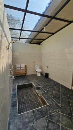 a bathroom with a toilet and a window at Luxcamp Dieng by Horison in Garung