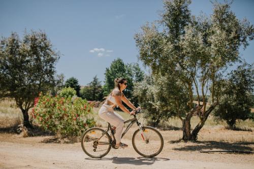 a woman riding a bike on a dirt road at Monte do Ramalho in Avis