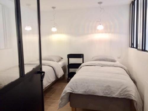 - une chambre avec 2 lits jumeaux et une chaise dans l'établissement Autour du Figuier, à Amélie-les-Bains-Palalda