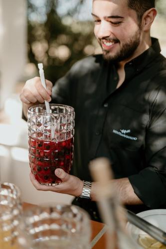 a man holding a drink with a cigarette in it at Monte do Ramalho in Avis