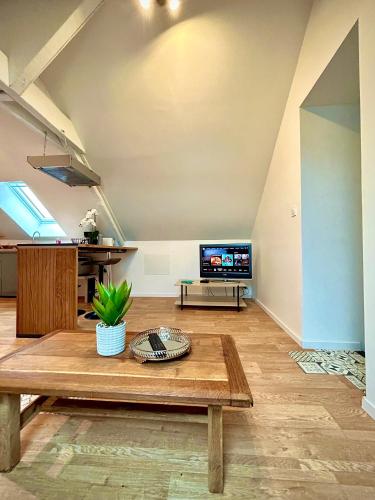 un salon avec une table et une télévision dans l'établissement Spacieux 2 pièces équipé accès facile, à Cuissai