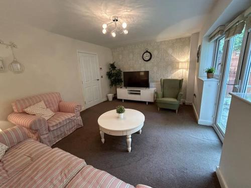 a living room with a couch and a table at Nice house close to the city centre and stadium in Manchester