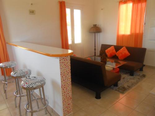 ein Wohnzimmer mit einem Sofa und einer Bar in der Unterkunft Ô PARADIS TERRESTRE Gîte passion in Capesterre