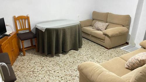 a living room with a table and a couch at Alojamiento Emilio in Quesada
