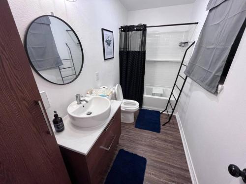 a bathroom with a sink and a mirror and a toilet at Pet Friendly Sleeps 9 HighSpeed WiFi 500MBPS Plus in Fresno