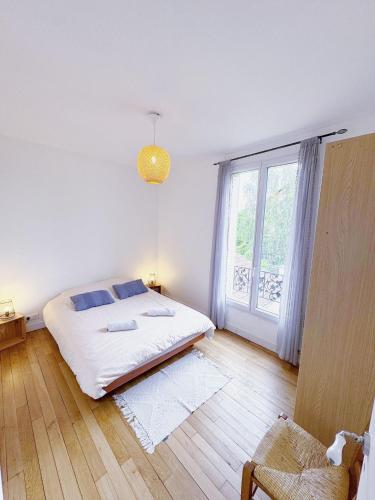 une chambre avec un lit et une grande fenêtre dans l'établissement Appartement entre Paris & Disney, à Le Perreux-Sur-Marne
