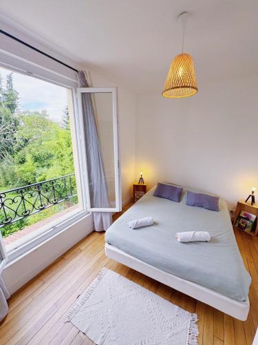 une chambre avec un lit et une grande fenêtre dans l'établissement Appartement entre Paris & Disney, à Le Perreux-Sur-Marne