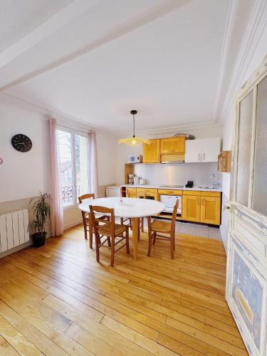 une cuisine et une salle à manger avec une table et des chaises dans l'établissement Appartement entre Paris & Disney, à Le Perreux-Sur-Marne