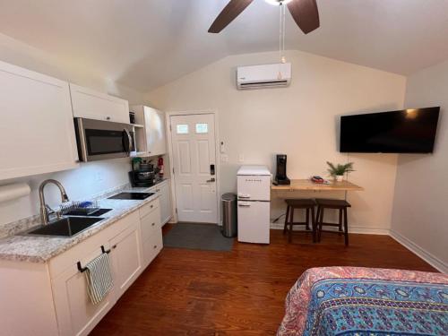 een keuken met witte kasten, een wastafel en een tafel bij Lux Studio W Kitchenette Pet Yes in Beaufort