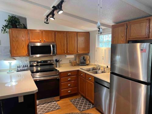 a kitchen with wooden cabinets and a stainless steel refrigerator at 10 Minutes to the Beach. Pet Yes in Harbor Island